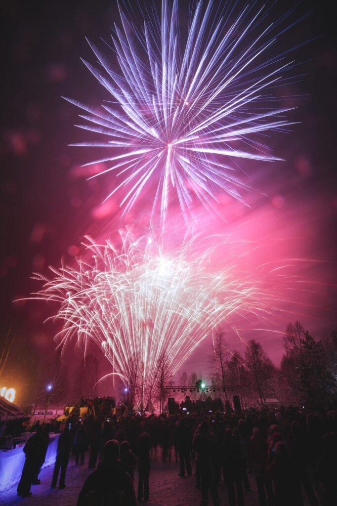 Fireworks over snowy trees during New Year in Rovaniemi