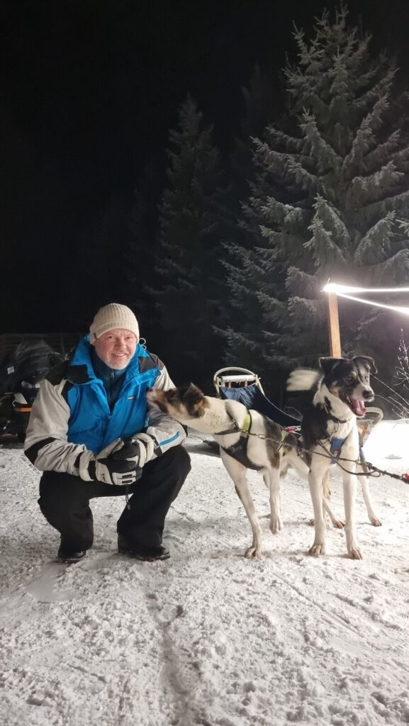 Guest with huskies before an evening sled ride in Vuokatti
