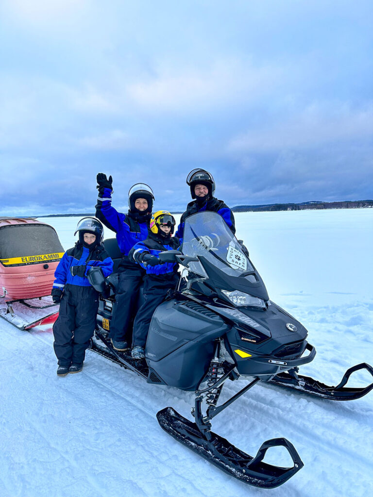 Family ready for a guided snowmobile excursion in snowy Vuokatti
